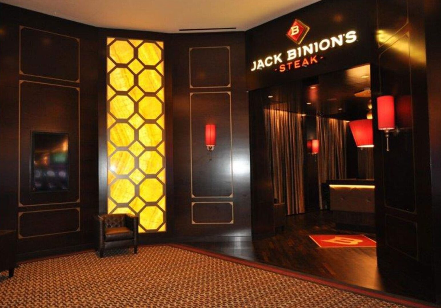 A room with a chair and a sign for jack binion 's steak.