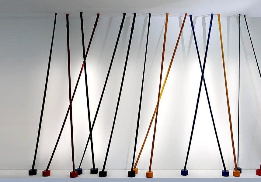Colorful jump ropes hanging against a white wall.