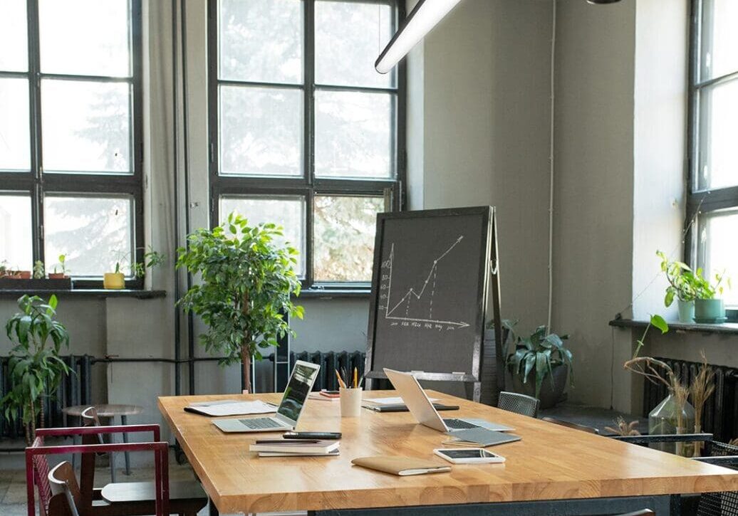 Bright, modern meeting room with large windows and wooden table.